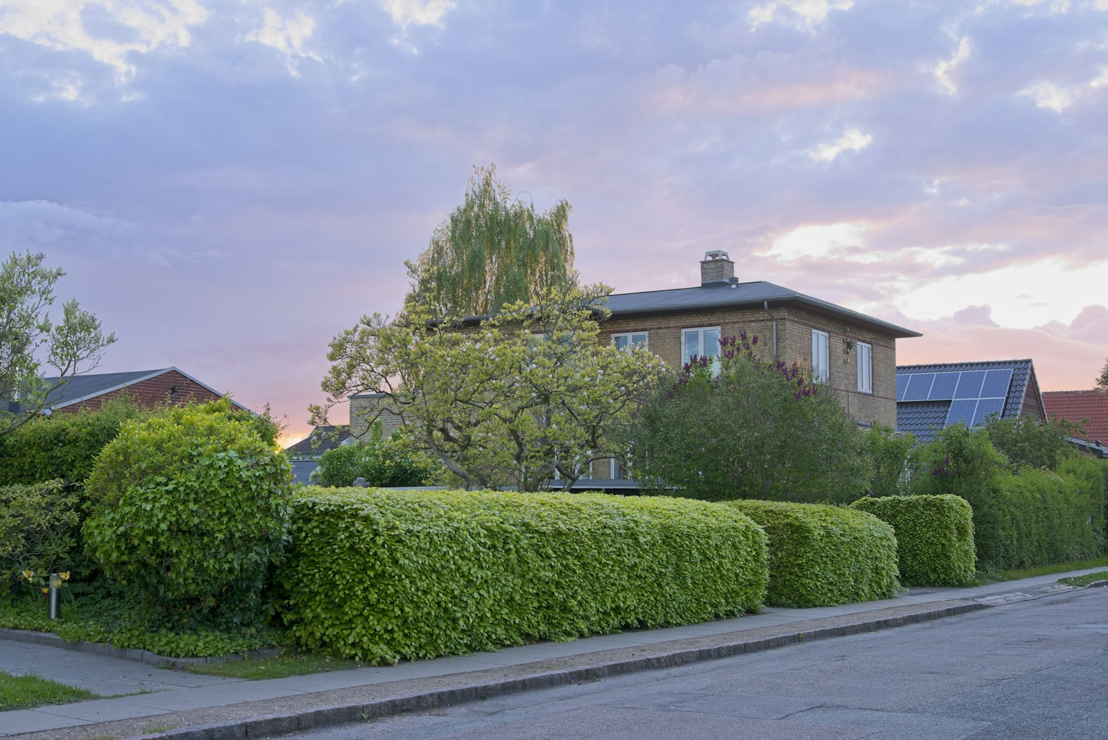 Einfamilienhaus am Abend mit beleuchteten Fenstern
