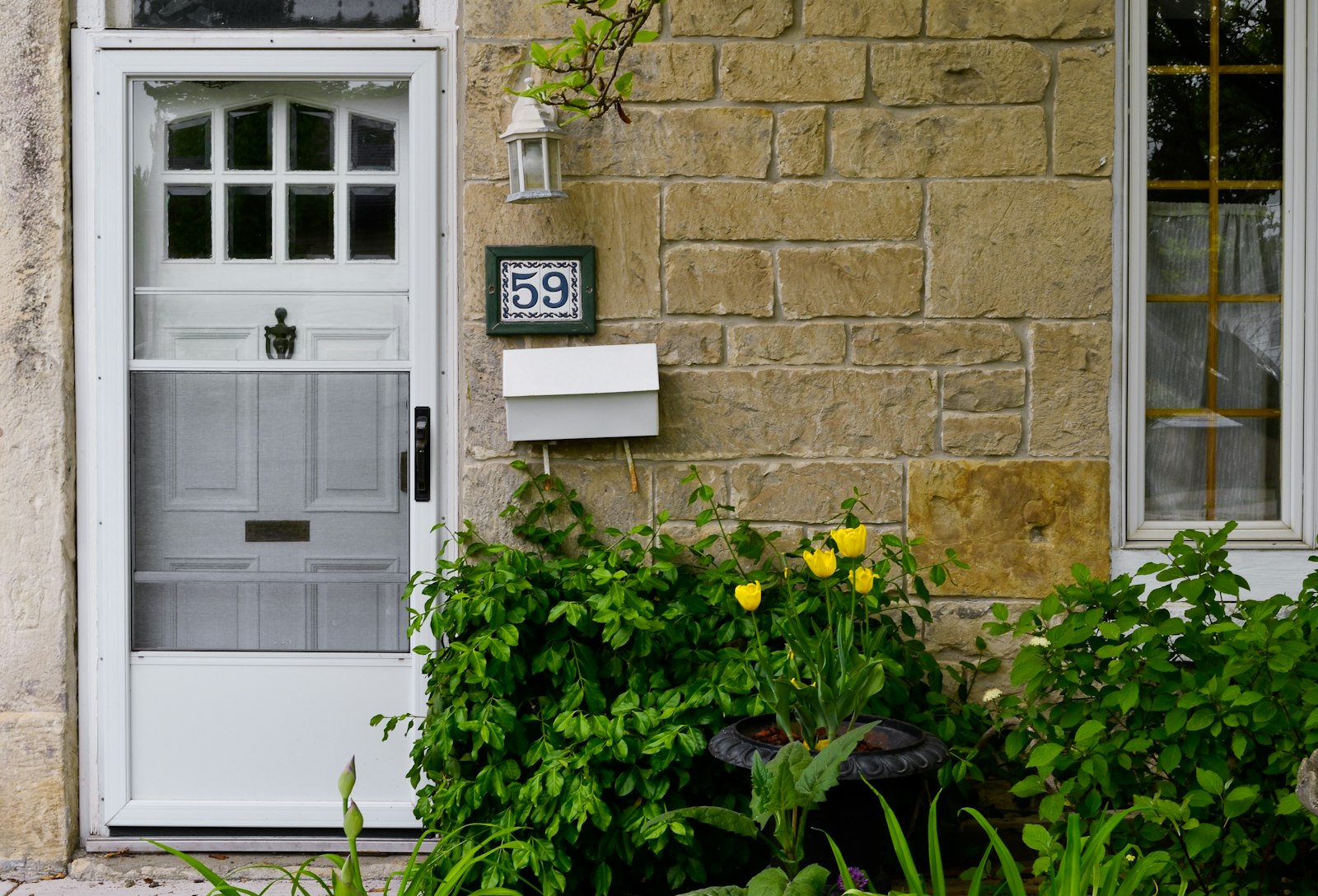 Weiße Haustür mit Hausnummer und Briefkasten