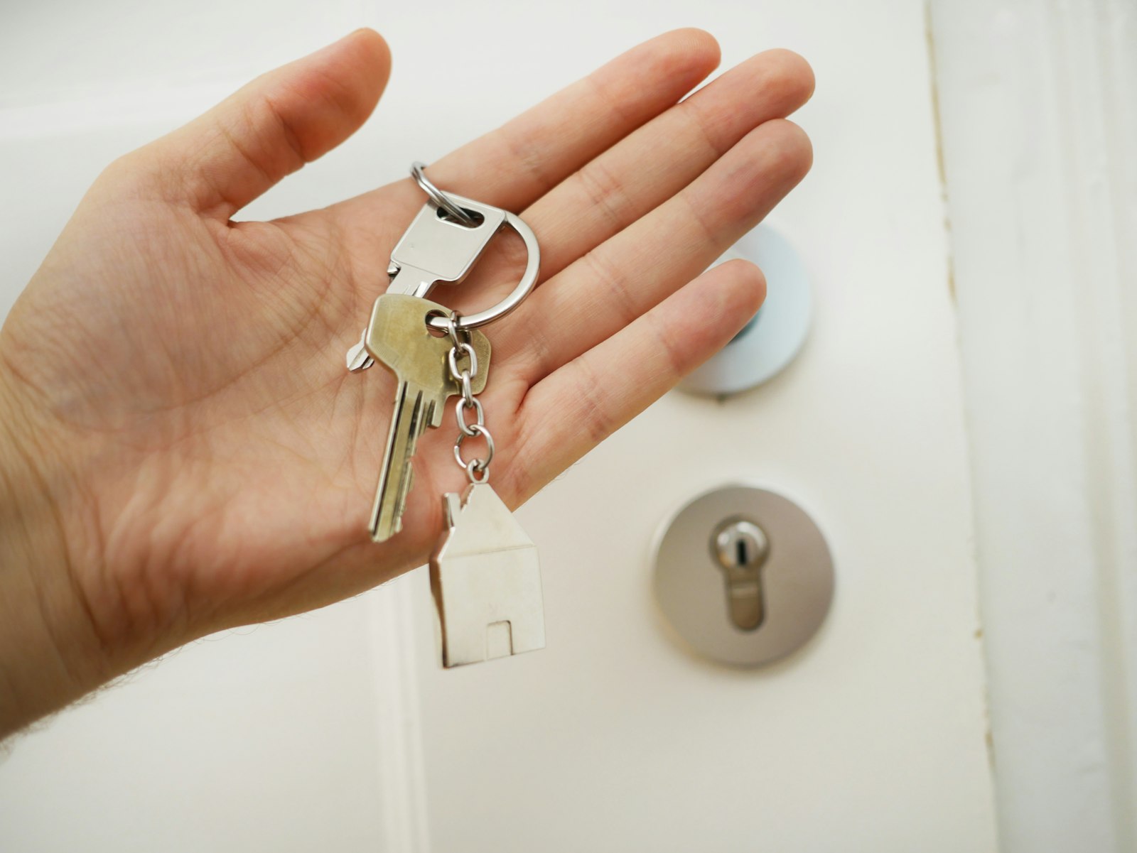 Hand an einem Türdrücker einer geschlossenen Wohnungstür