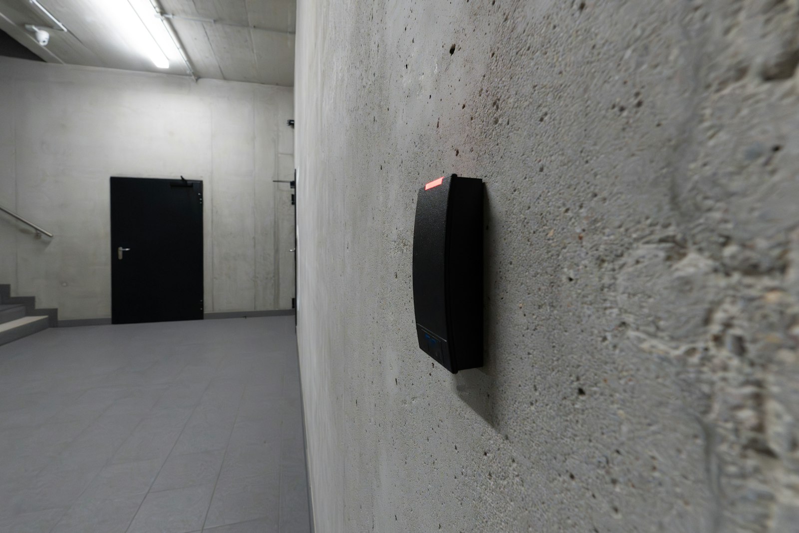 Elektronischer Türzylinder an einer Wohnungstür, daneben die Steuerung per Smartphone